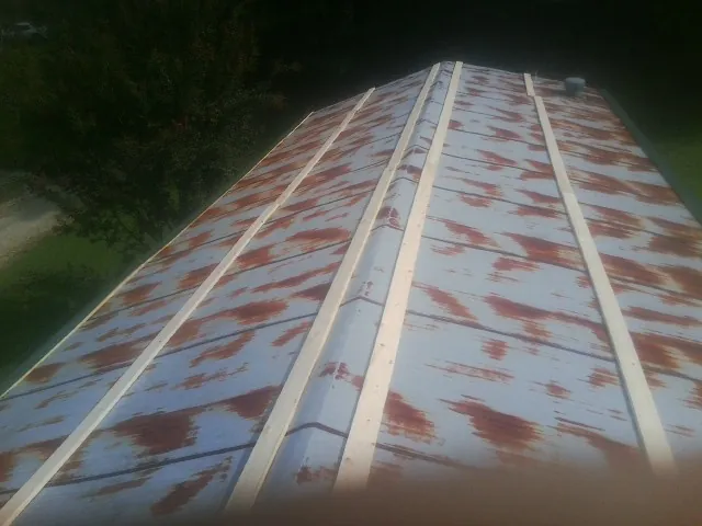 Rusted metal roof panels with new wood purlins before replacement — Storm Damage Roof Repair in Valley Spring by Roofing Brothers