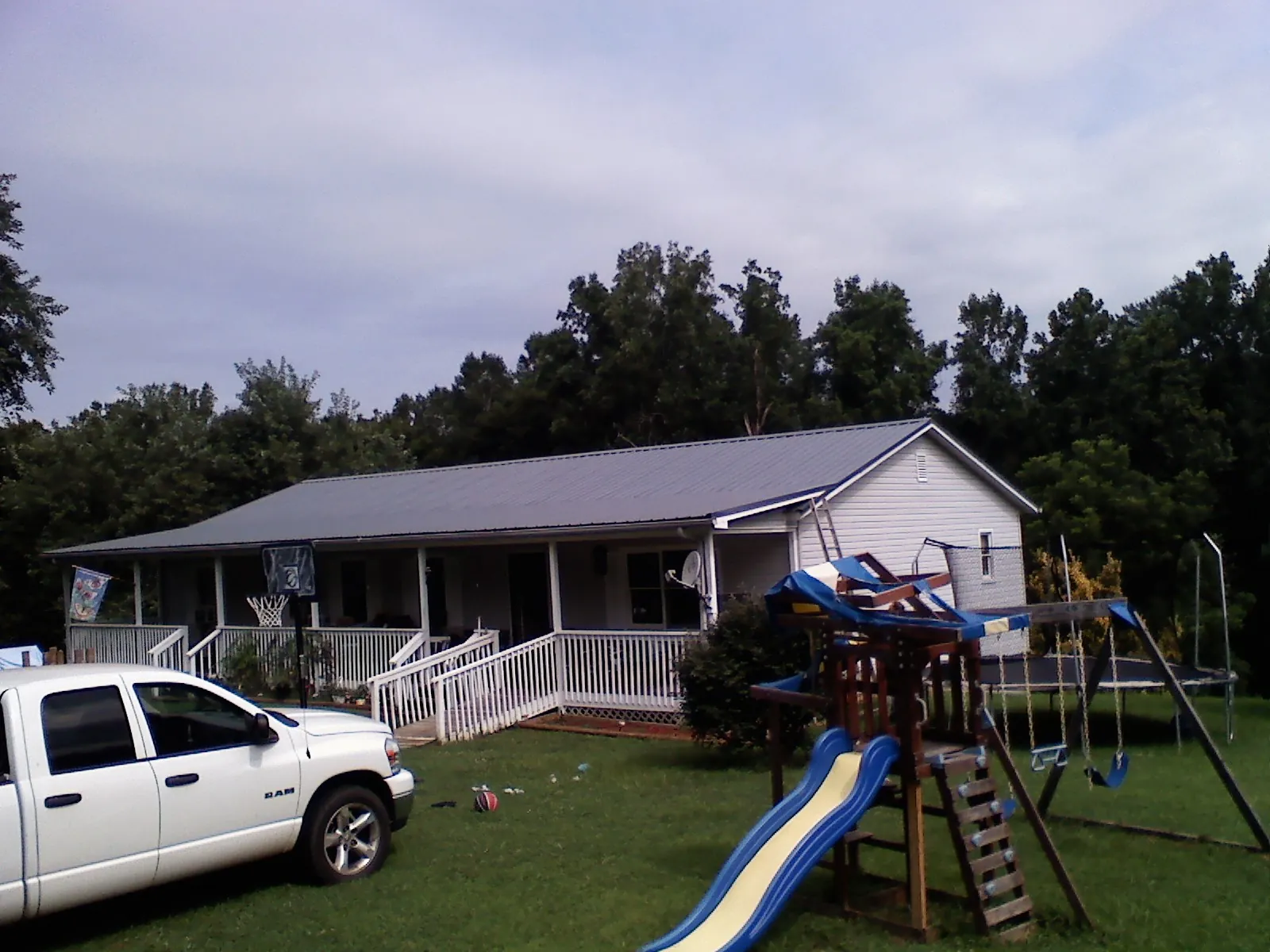 Dark metal roof on a country home with a full length front porch in Valley Spring