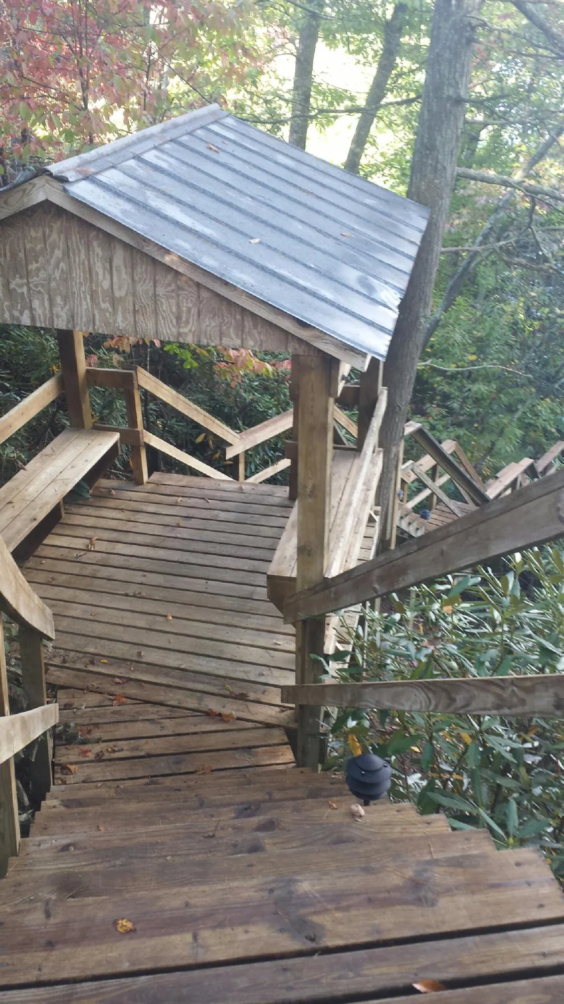 Metal roofed shelter over wooden steps on a wooded walkway — Skylight Repair & Installation work by our crew in Valley Spring